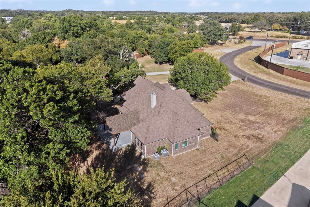 108 Winding Way Azle, TX 76020 - Photo 38 of 38 Aerial view showing the roof, stone and siding exterior, and mature surrounding trees on private road