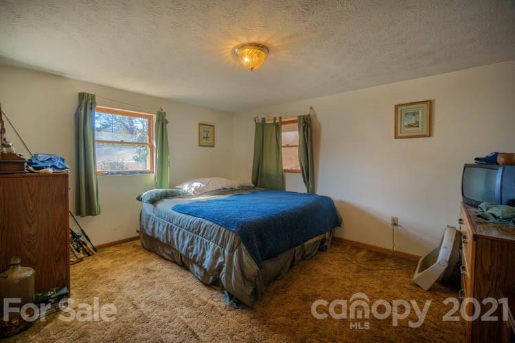 4904 Crabtree Mountain Road Clyde, NC 28721 - Photo 19 of 37 a bedroom with a bed and dresser with wooden floor
