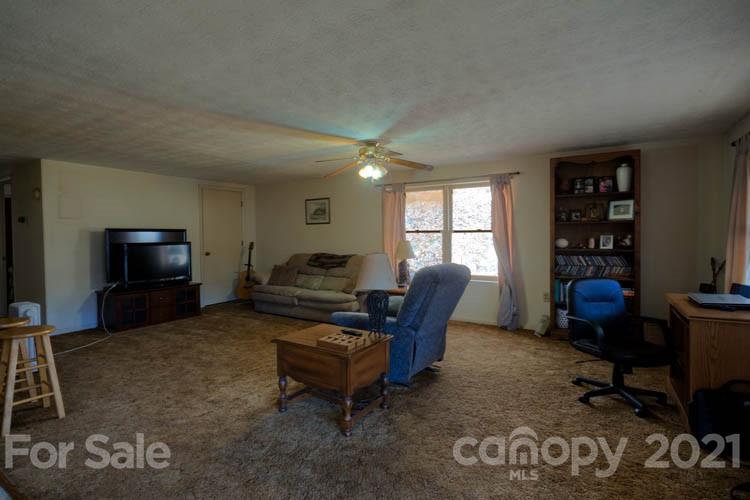 4904 Crabtree Mountain Road Clyde, NC 28721 - Photo 26 of 37 a living room with furniture a large window and a flat screen tv