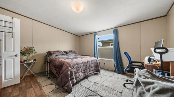 a bedroom with a bed and wooden floor