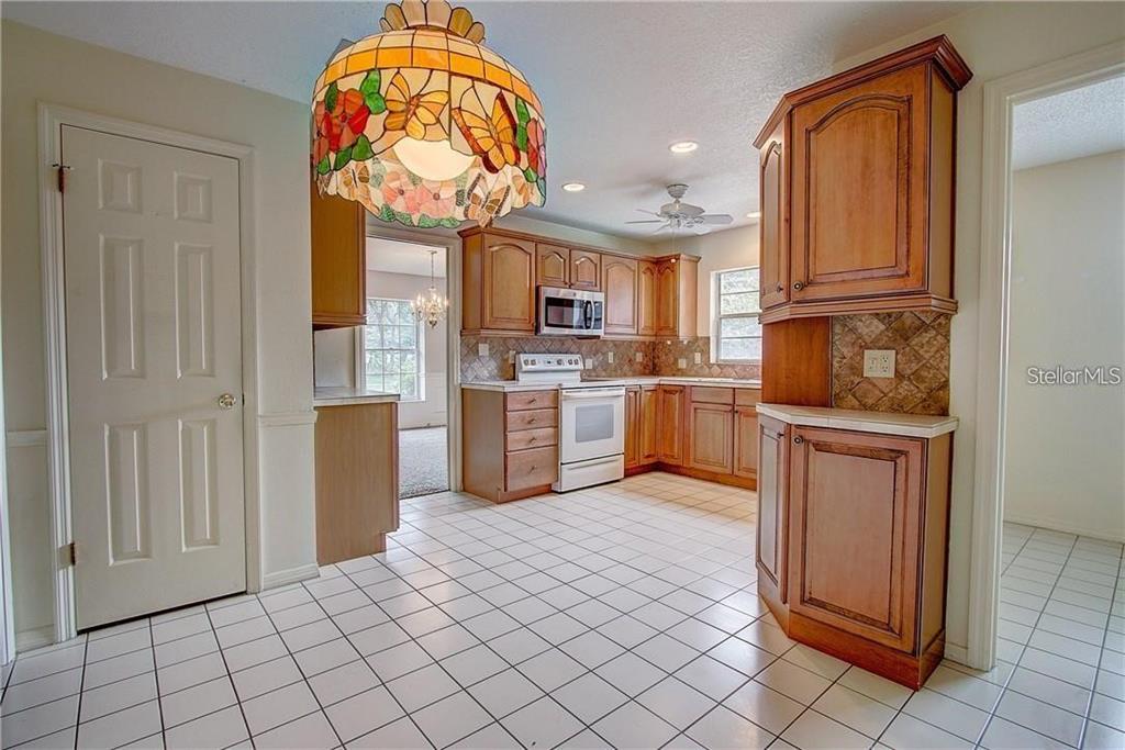 1201 Wolverine Trail Winter Springs, FL 32708 - Photo 5 of 29 a kitchen with stainless steel appliances granite countertop a refrigerator sink and cabinets