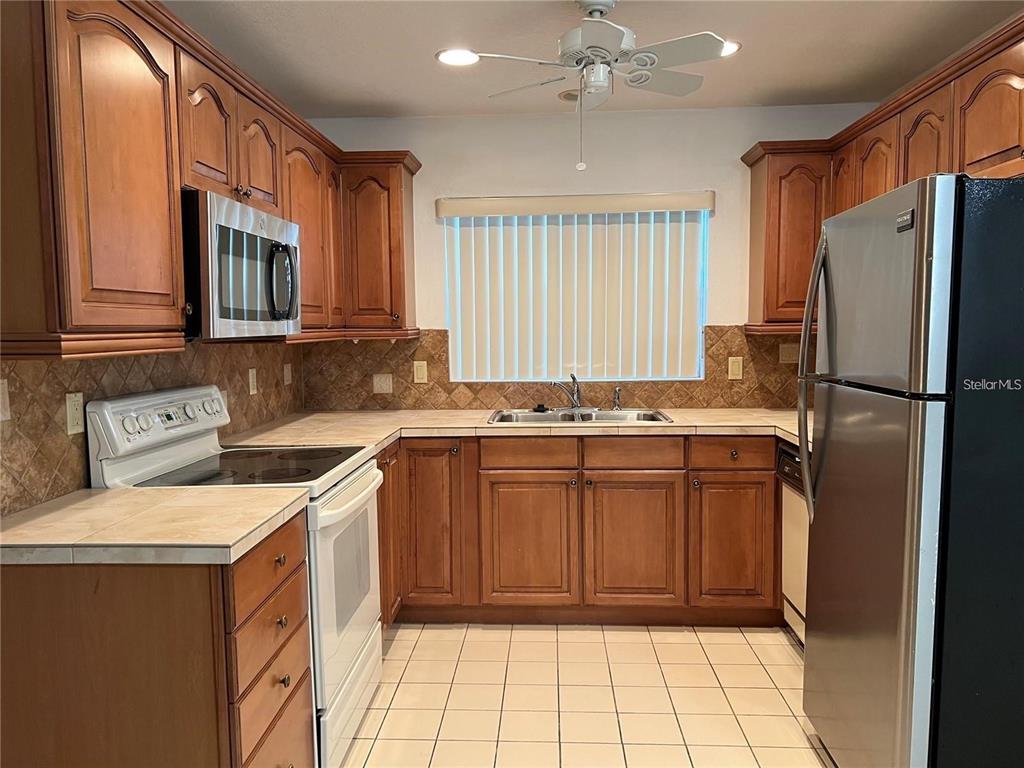 1201 Wolverine Trail Winter Springs, FL 32708 - Photo 6 of 29 a kitchen with a refrigerator sink and cabinets