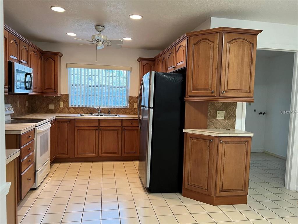1201 Wolverine Trail Winter Springs, FL 32708 - Photo 8 of 29 a kitchen with stainless steel appliances granite countertop a refrigerator and a stove