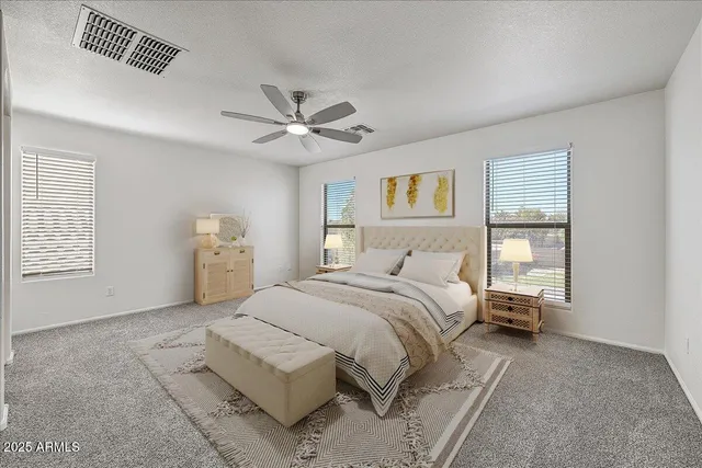 a spacious bedroom with a bed and a chandelier