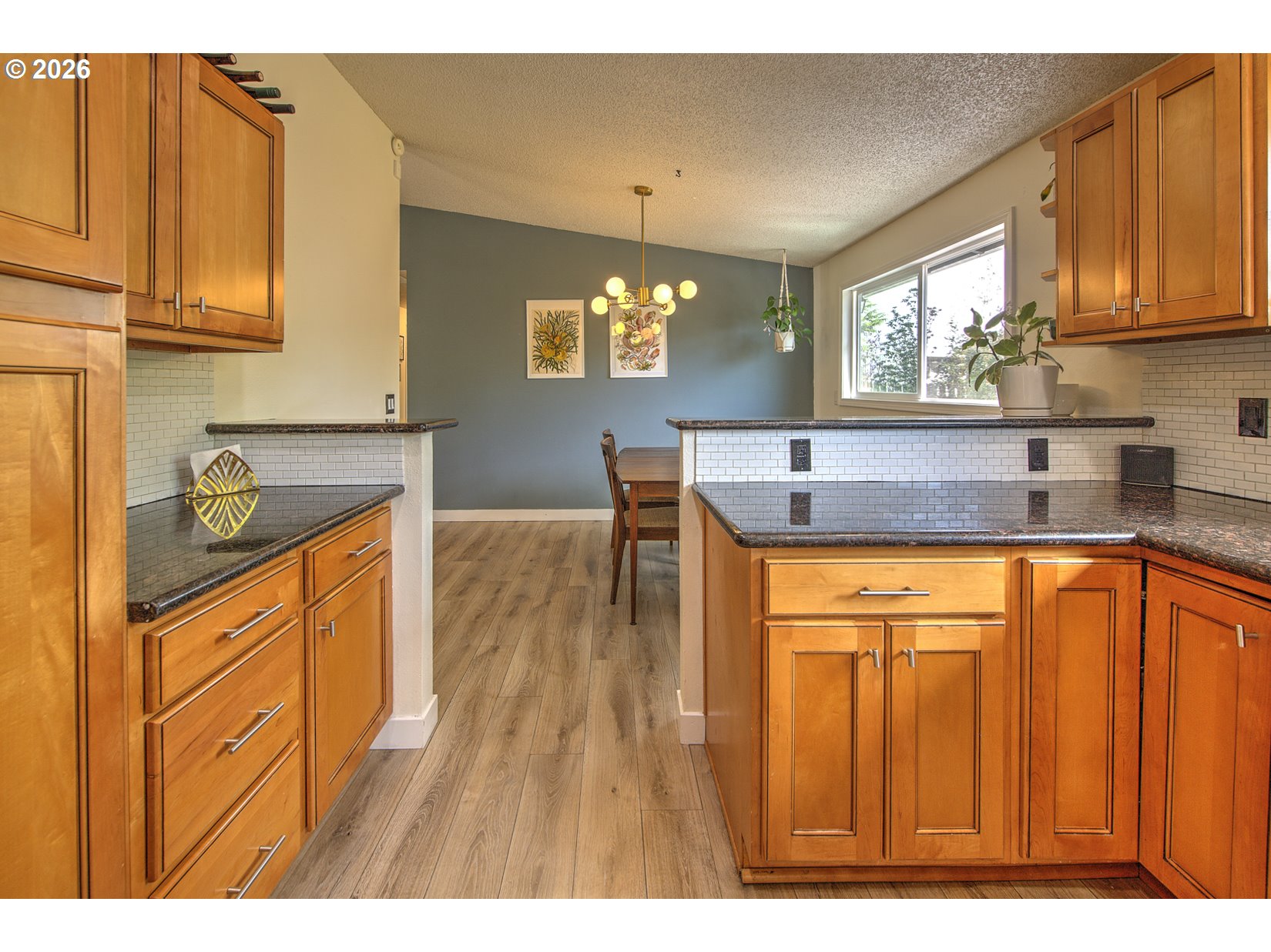 16020 Southwest Rosa Road Beaverton, OR 97007 - Photo 29 of 42 a kitchen with stainless steel appliances granite countertop wooden cabinets a sink a stove a dining table and chairs with wooden floor