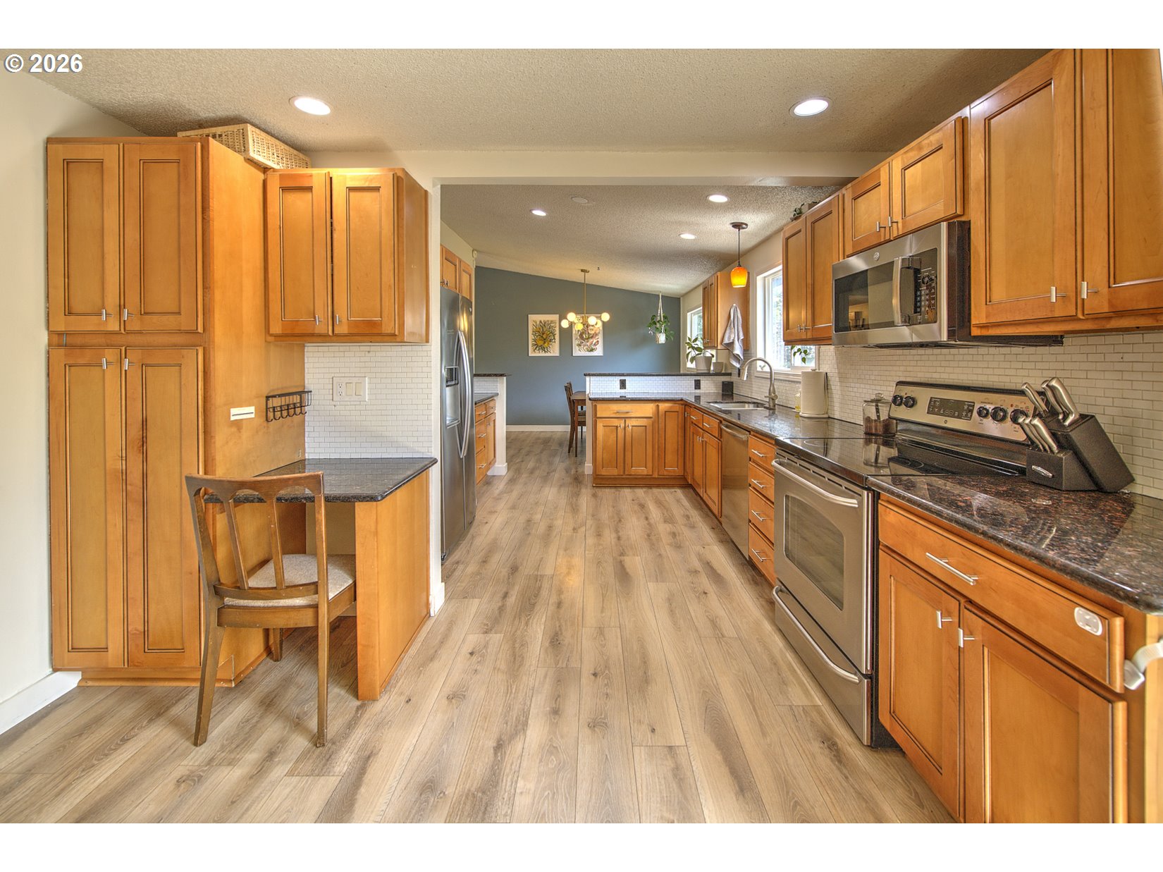 16020 Southwest Rosa Road Beaverton, OR 97007 - Photo 33 of 42 a open kitchen with stainless steel appliances granite countertop a refrigerator a sink dishwasher and wooden cabinets with wooden floor