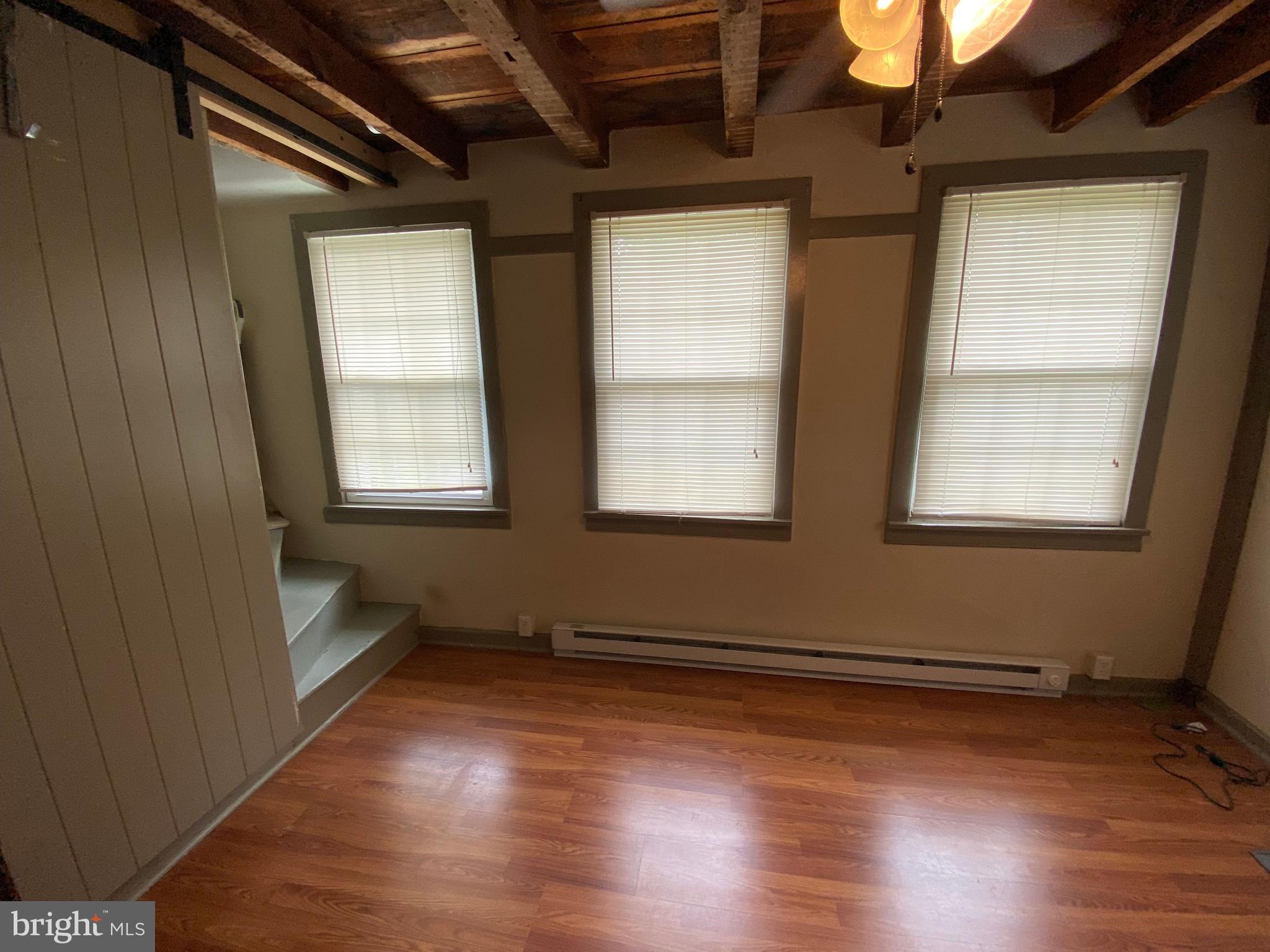 114 North Street Lewisberry, PA 17339 - Photo 3 of 4 an empty room with wooden floor and windows