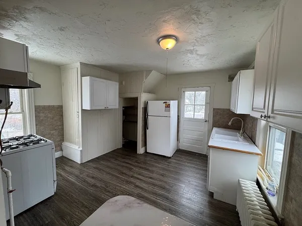a kitchen with stainless steel appliances granite countertop a refrigerator a stove and a wooden floors