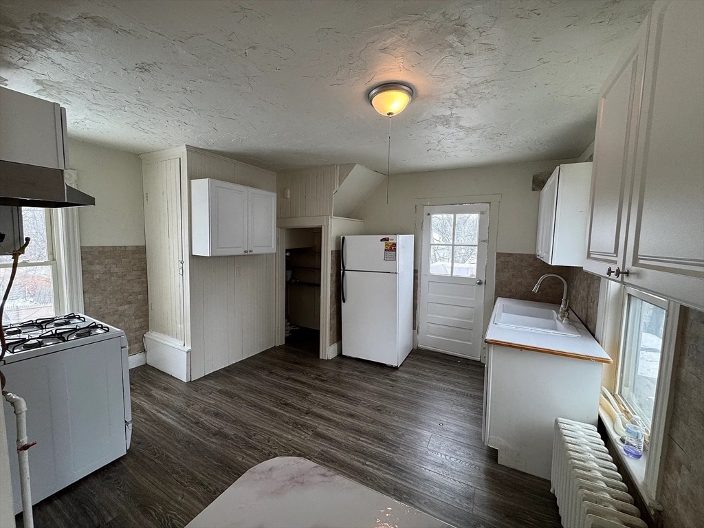 78 Birch Street, Unit 2 Worcester, MA 01603 - Photo 3 of 12 a kitchen with stainless steel appliances granite countertop a refrigerator a stove and a wooden floors