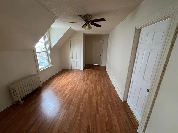 a view of a livingroom with wooden floor and a ceiling fan