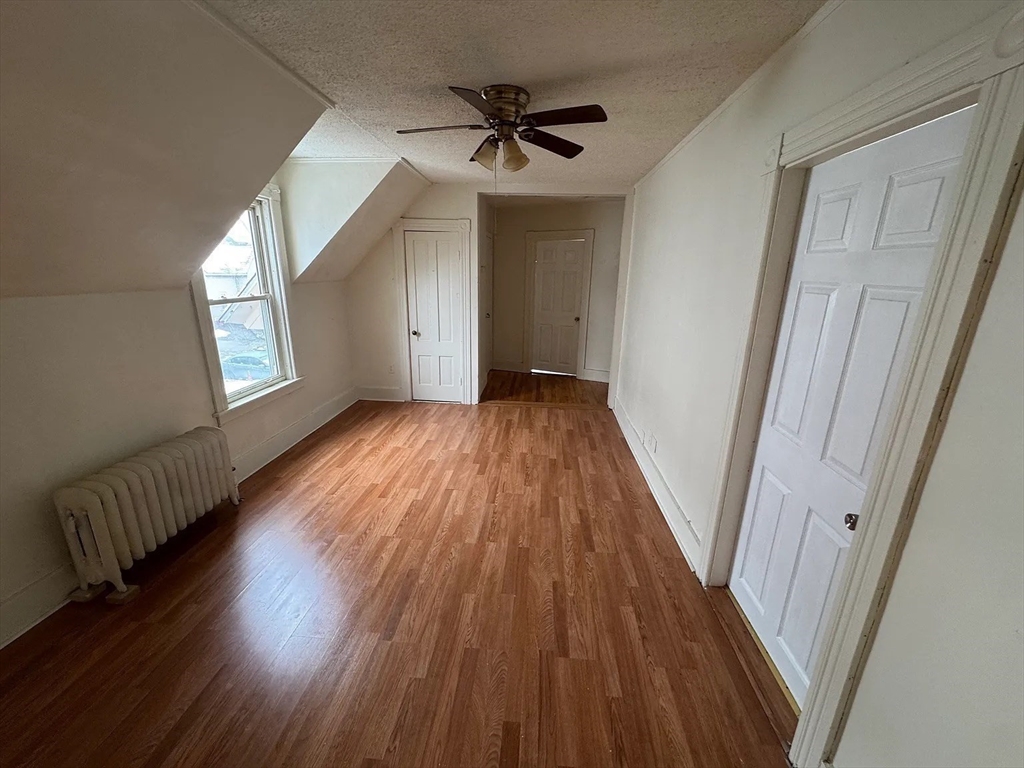 78 Birch Street, Unit 2 Worcester, MA 01603 - Photo 5 of 12 a view of a livingroom with wooden floor and a ceiling fan