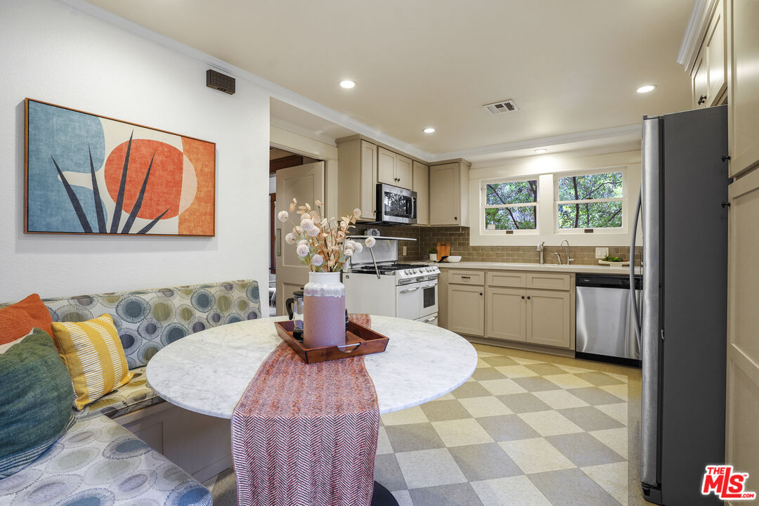 337 Cherry Avenue Long Beach, CA 90802 - Photo 20 of 52 a kitchen with a sink a stove a microwave a dining table and chairs