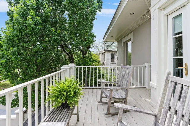 a view of balcony with wooden floor and fence