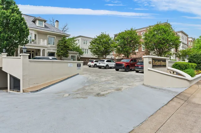 a view of a white house with a large space and a car park