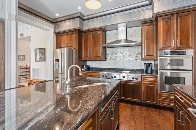 a kitchen with stainless steel appliances granite countertop a stove top oven a sink a counter space and cabinets