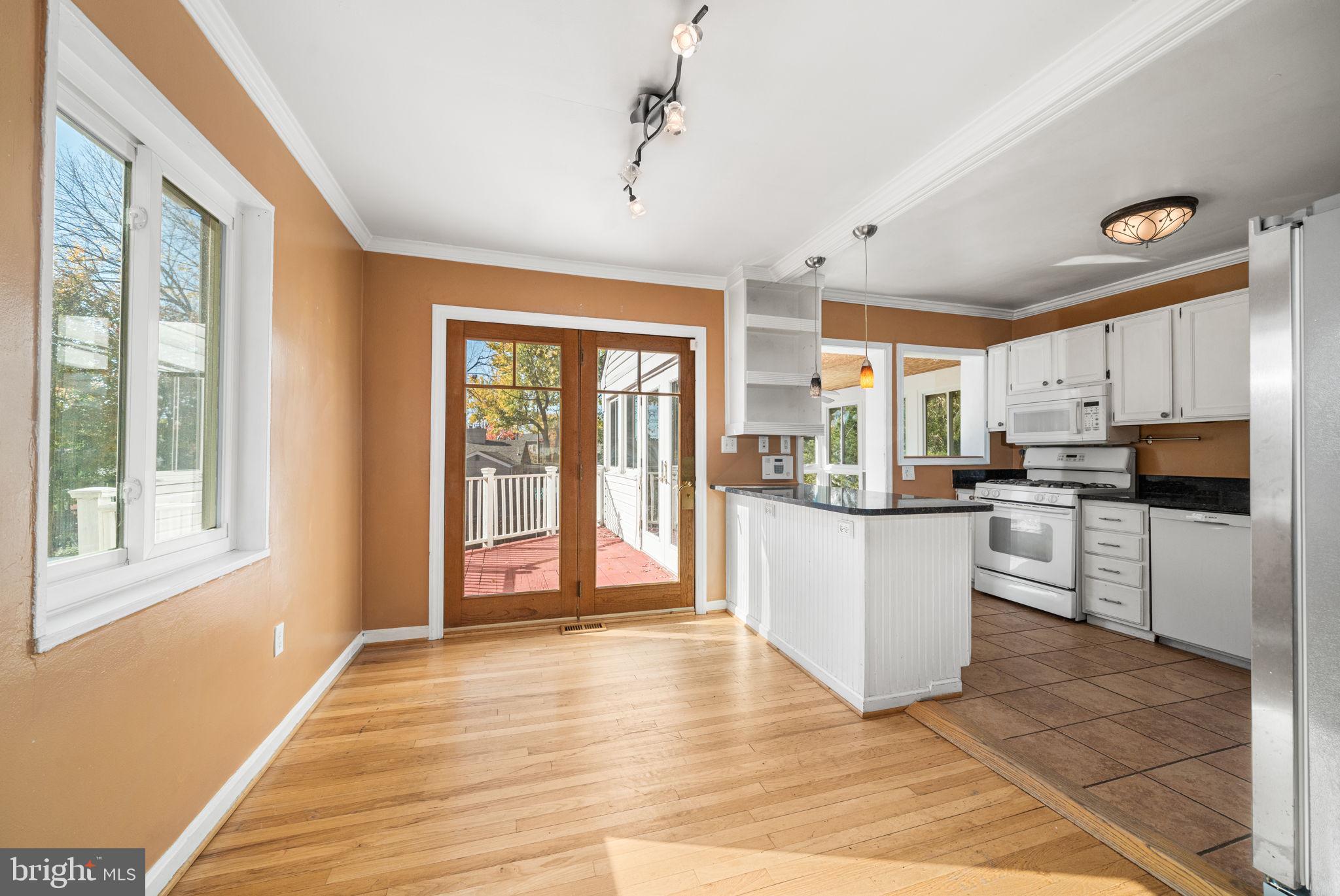 3924 Taney Avenue Alexandria, VA 22304 - Photo 12 of 57 a kitchen with stainless steel appliances granite countertop a refrigerator a stove a sink dishwasher and white cabinets with wooden floor