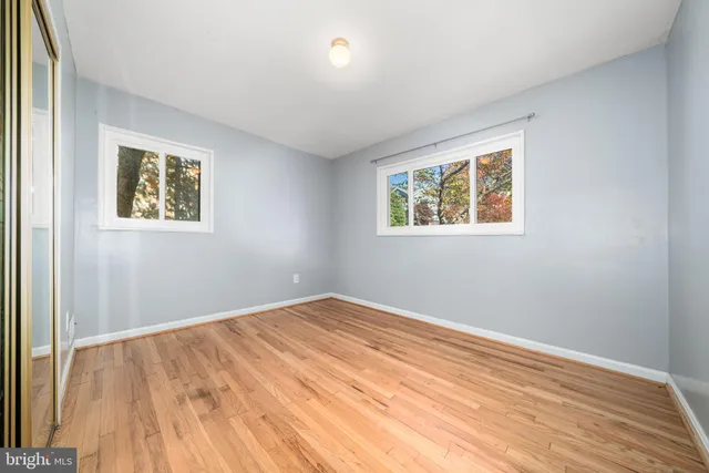 a view of a room with wooden floor and a ceiling fan