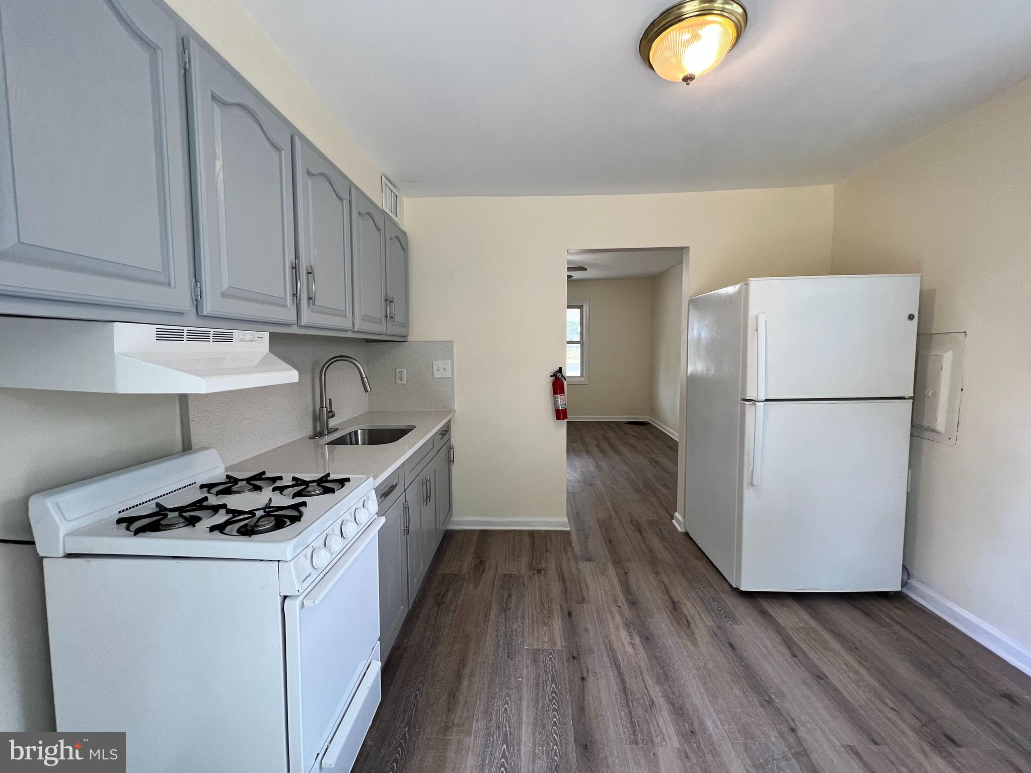 1008 Terrace Boulevard Trenton, NJ 08618 - Photo 7 of 18 a kitchen with a refrigerator a stove top oven a counter space and wooden floor