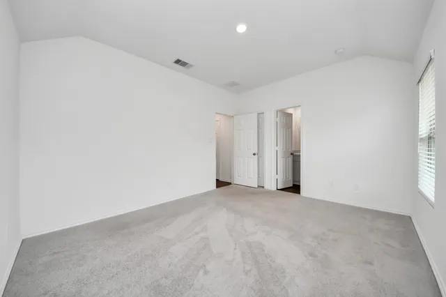 an empty room with windows and closet