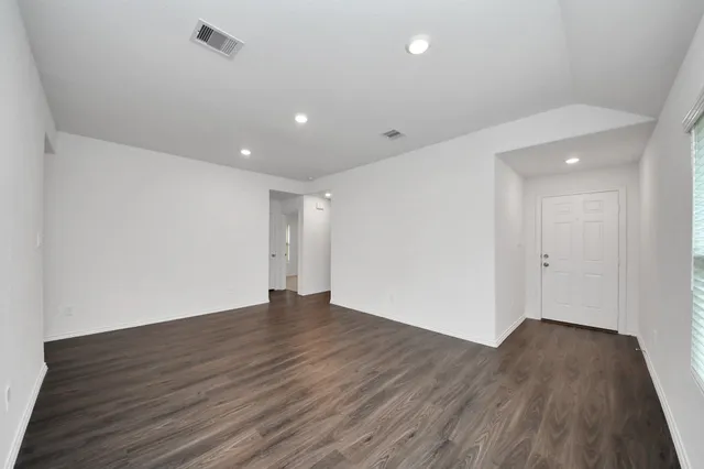 a view of an empty room with wooden floor