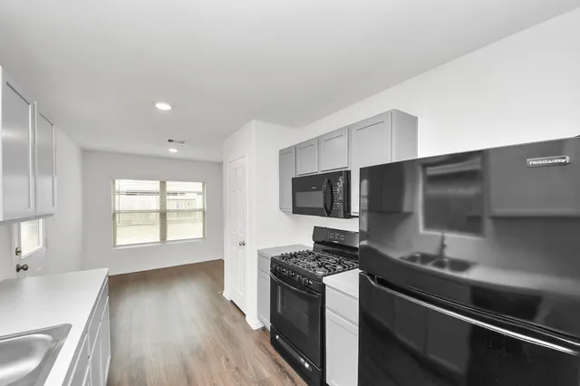 a kitchen with stainless steel appliances kitchen island granite countertop a stove and a sink