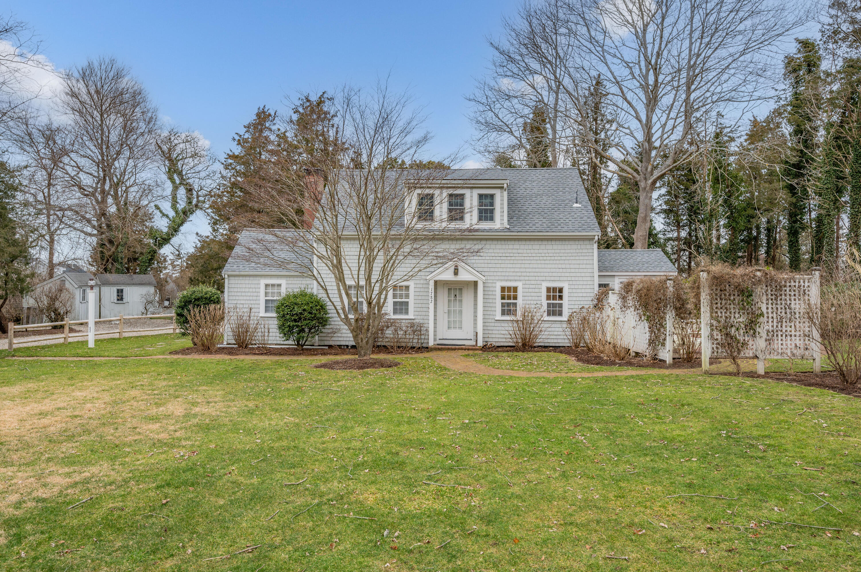 a view of a house with a big yard and large trees