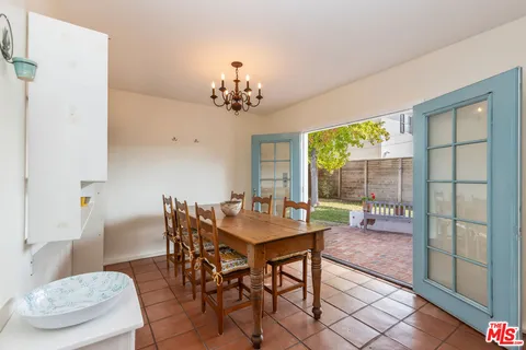 a dining room with chandelier and wooden floor