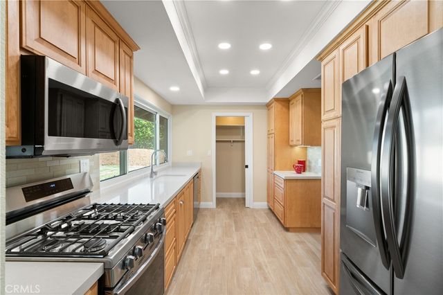 a kitchen with stainless steel appliances granite countertop a stove refrigerator and microwave