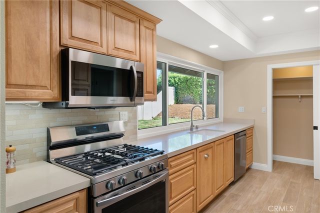 a kitchen with stainless steel appliances granite countertop a stove and a microwave