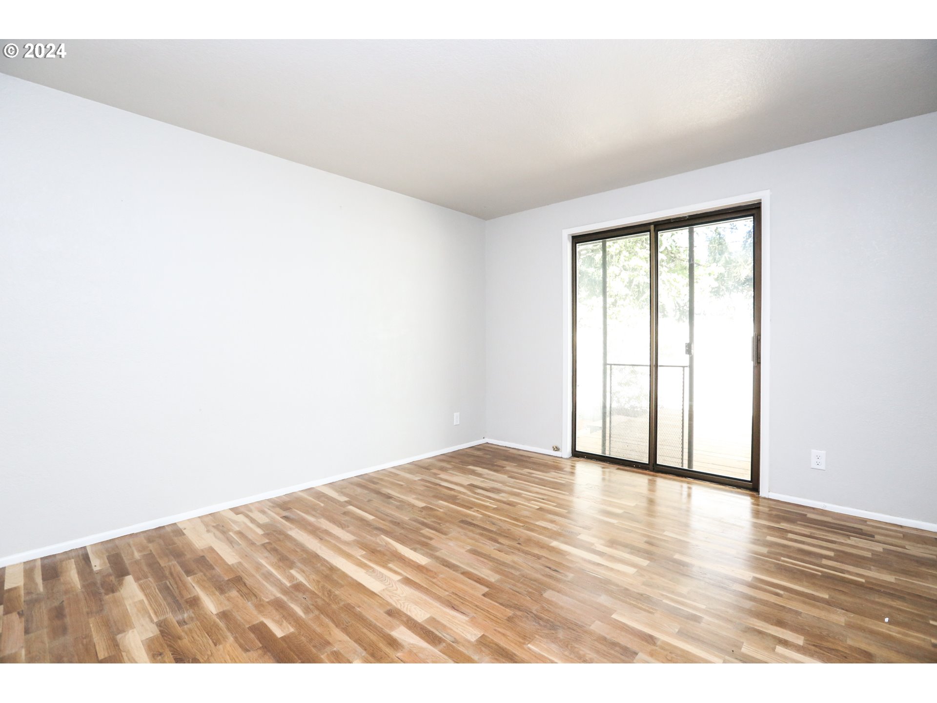 805 Kelly Lane Eugene, OR 97404 - Photo 11 of 31 a view of an empty room with wooden floor and a window