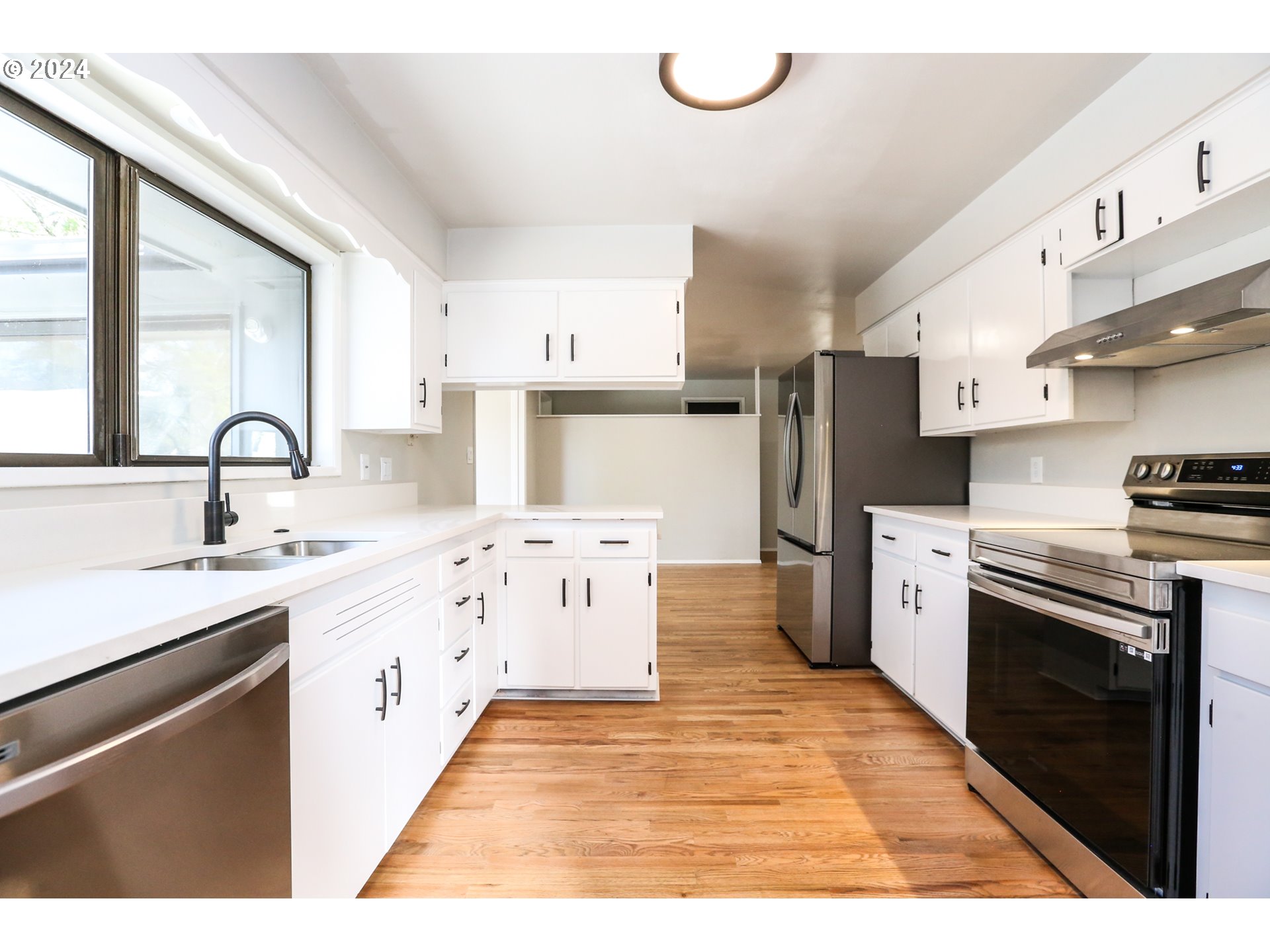805 Kelly Lane Eugene, OR 97404 - Photo 4 of 31 a kitchen with stainless steel appliances kitchen island wooden cabinets a sink dishwasher a stove and a refrigerator with wooden floor