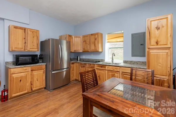 a kitchen with stainless steel appliances granite countertop a refrigerator a stove a sink and a microwave