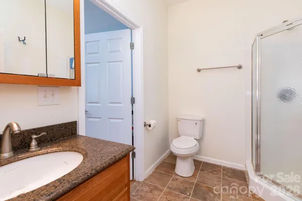 a bathroom with a granite countertop sink toilet and shower