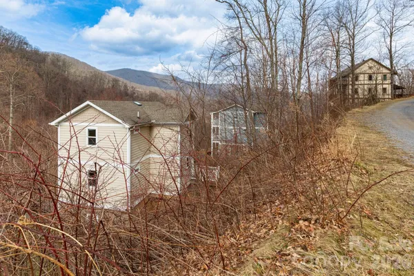 a view of a white house with a yard covered with snow in the background