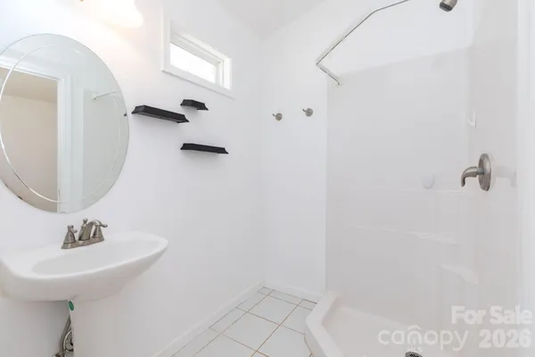 a bathroom with a sink a mirror and shower
