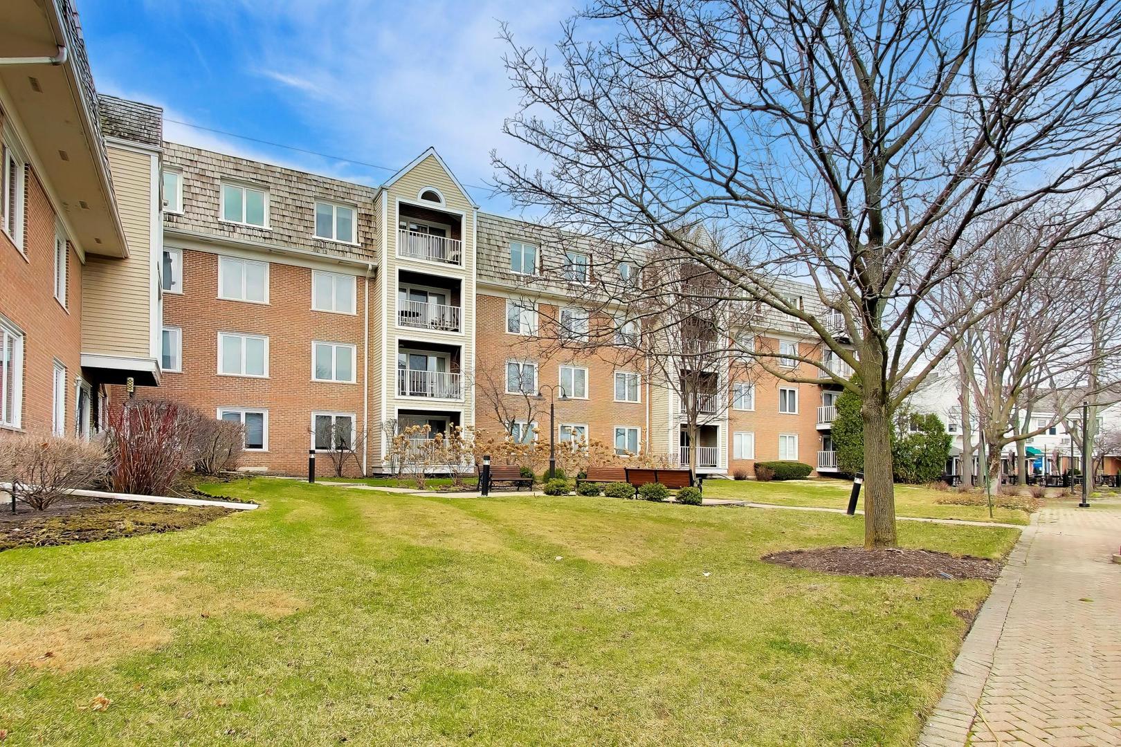 308 North Happ Road, Unit 108 Northfield, IL 60093 - Photo 26 of 31 a large building with a big yard and large trees