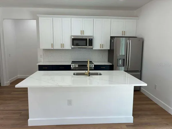 a close view of a refrigerator a stove a microwave and cabinets