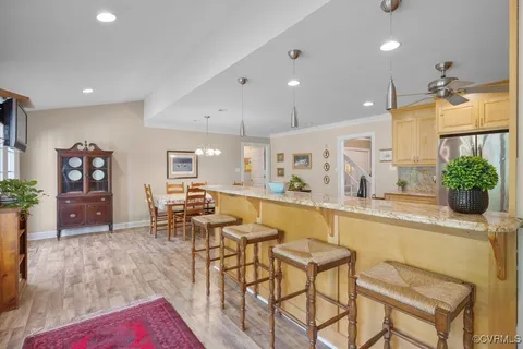 a view of a dining room and livingroom with furniture wooden floor a chandelier