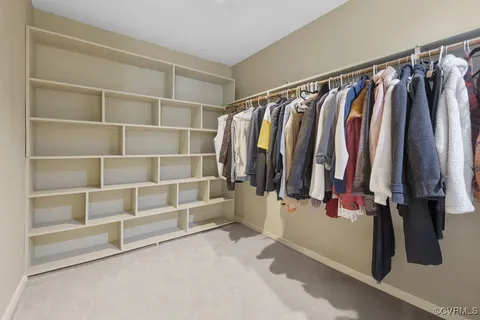 a view of walk in closet with clothes and shoes