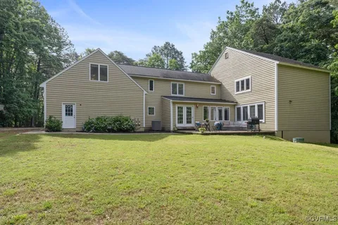 a front view of house with yard and trees in the background