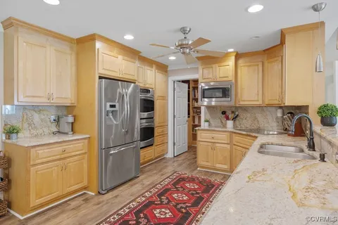 a kitchen with granite countertop a refrigerator stove and sink