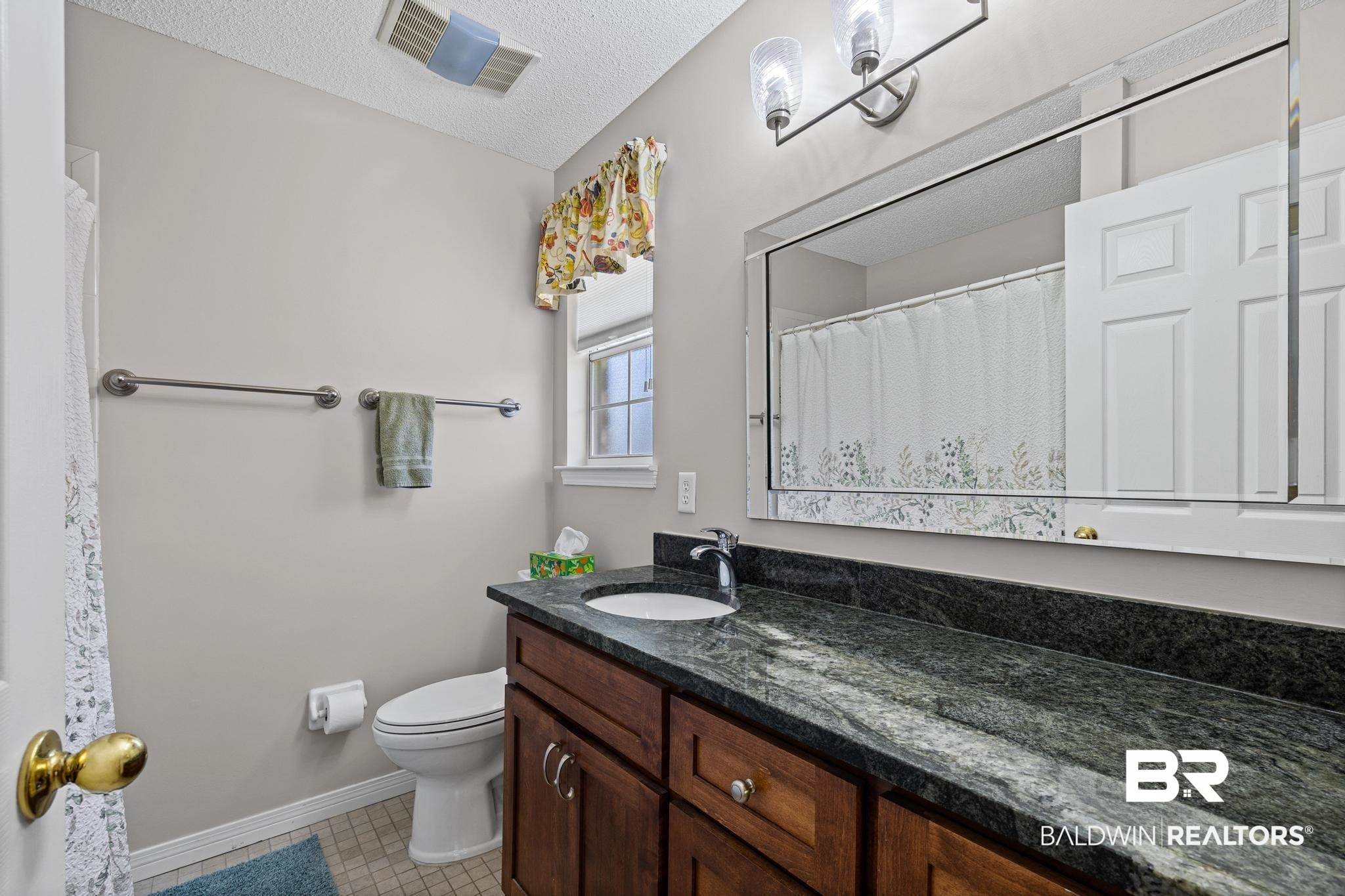 2881 Eslava Circle Lillian, AL 36549 - Photo 18 of 58 Bathroom with vanity, a textured ceiling, and curtained shower