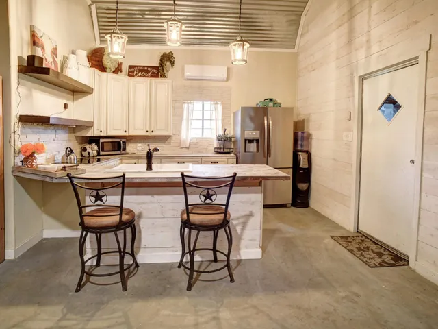 a kitchen with stainless steel appliances granite countertop white cabinets and a window