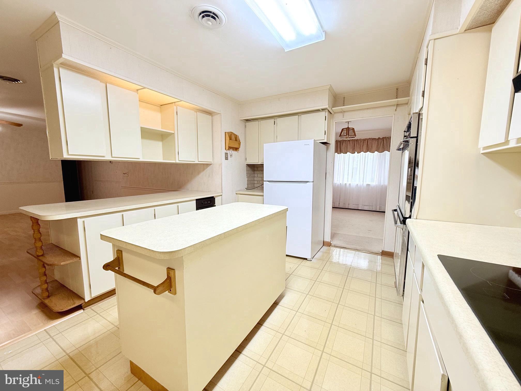 48724 Curleys Road Ridge, MD 20680 - Photo 25 of 47 a kitchen with a refrigerator a stove top oven and cabinets