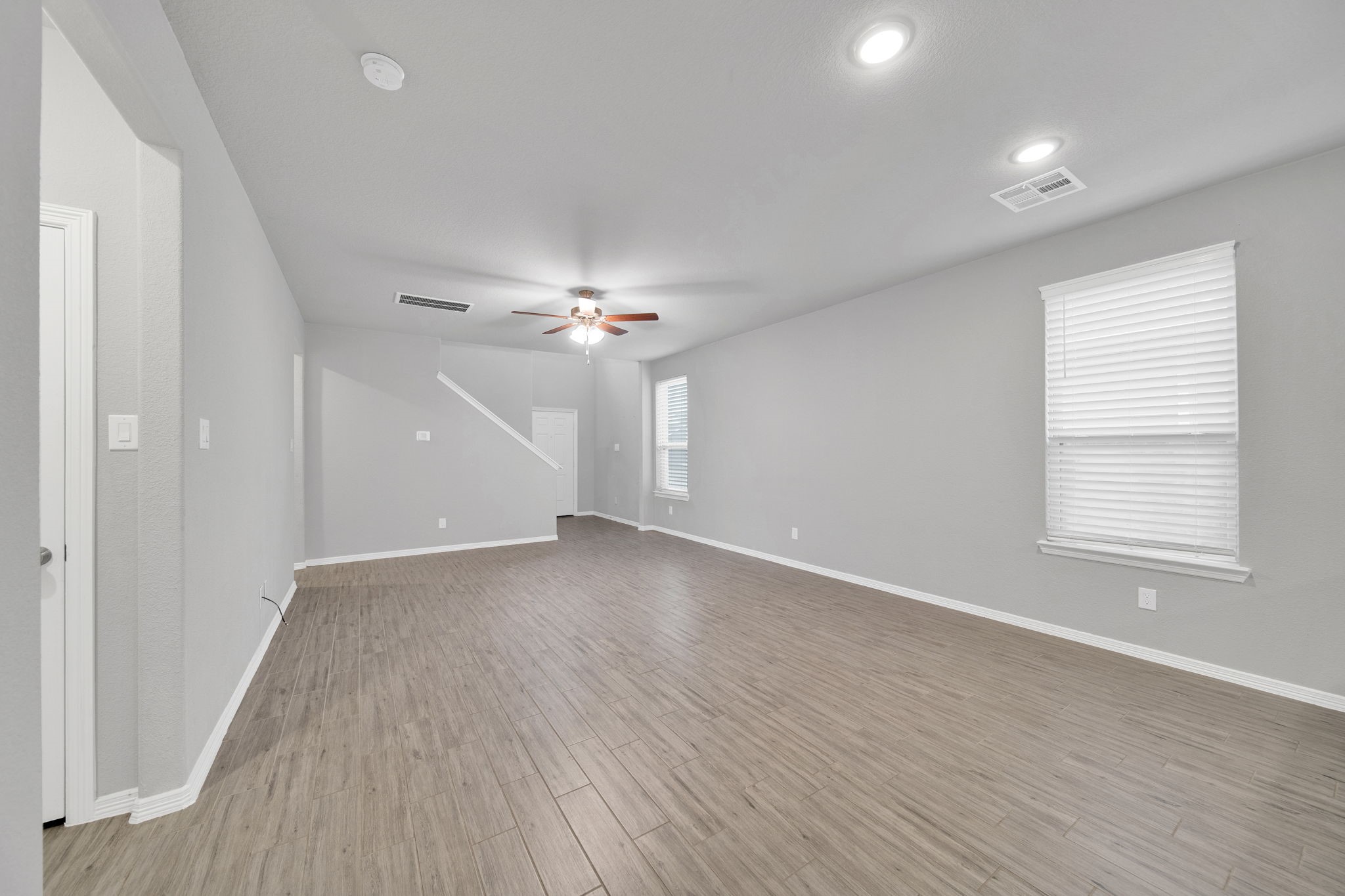 24722 Colony Meadow Trail Houston, TX 77336 - Photo 6 of 16 an empty room with wooden floor chandelier fan and windows