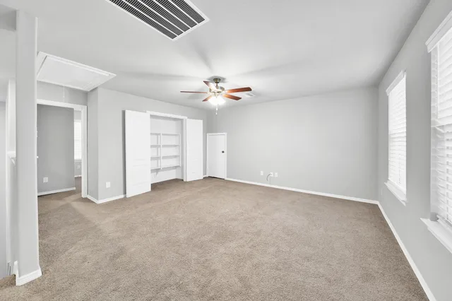 an empty room with closet and windows