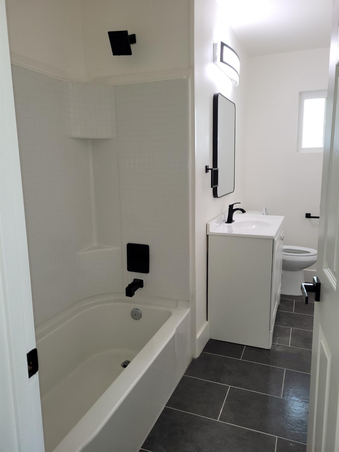 8625 La Vaca Way Hanford, CA 93230 - Photo 11 of 20 a bathroom with a bathtub a toilet a sink and mirror