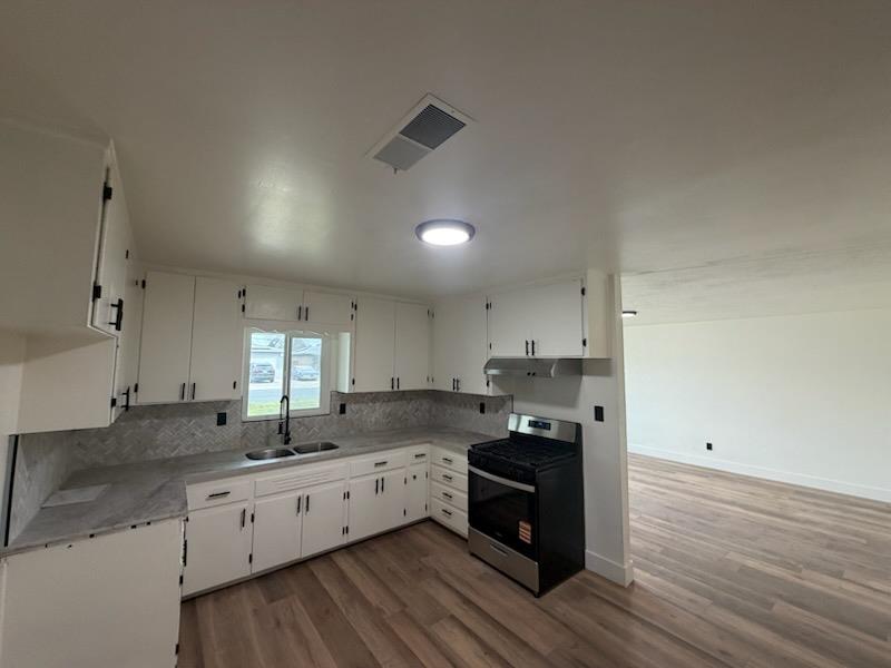8625 La Vaca Way Hanford, CA 93230 - Photo 7 of 20 a large kitchen with stainless steel appliances granite countertop a stove a sink and a granite counter tops with wooden floors