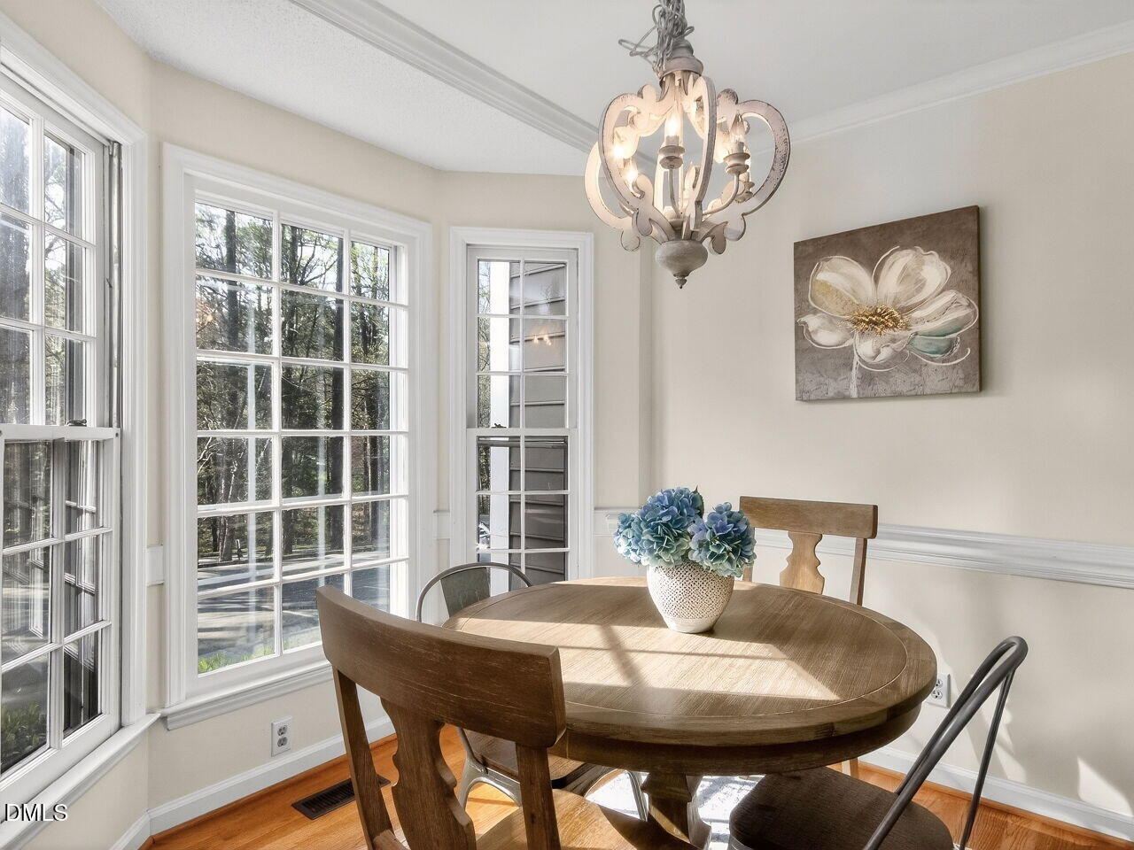 6703 Queen Annes Drive Raleigh, NC 27613 - Photo 4 of 20 a dining room with furniture a large window and wooden floor