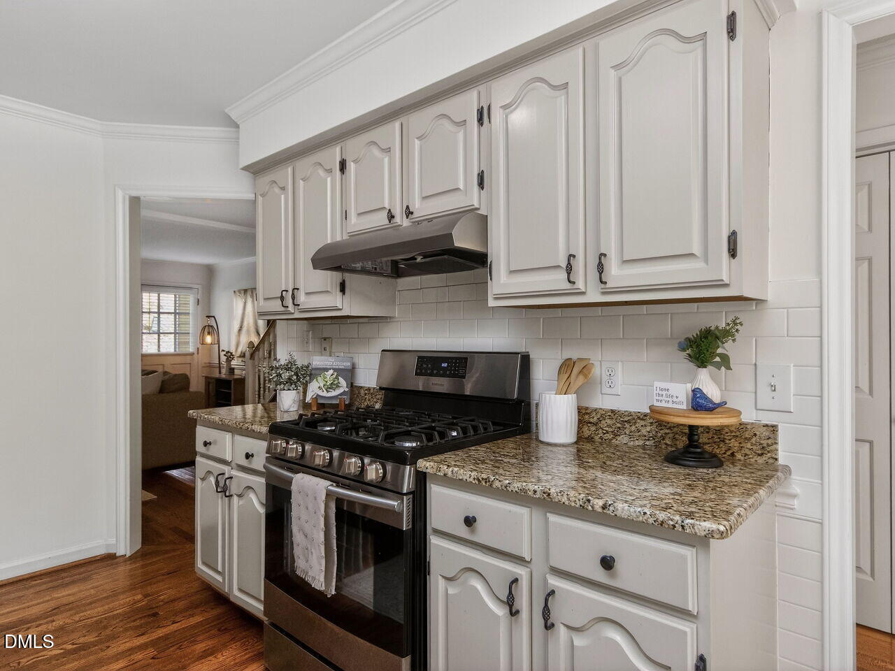 6703 Queen Annes Drive Raleigh, NC 27613 - Photo 8 of 20 a kitchen with stainless steel appliances granite countertop a stove a sink and white cabinets